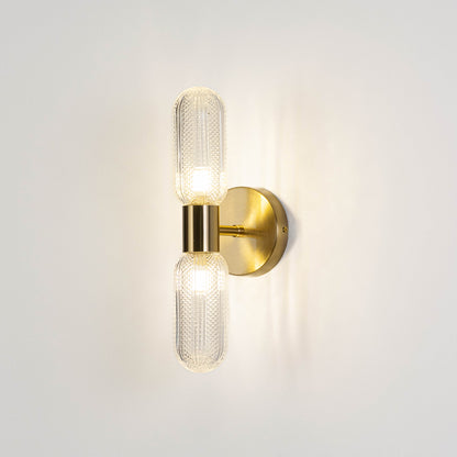 Contemporary wall light in gold metal finish with dual glass tube shades for bedroom or living decor lighting white background.