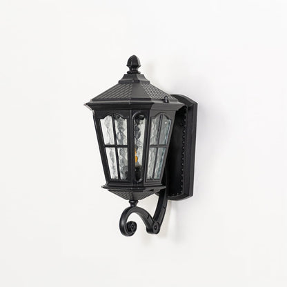 Outdoor wall lantern in black metal switched off on white background highlighting textured glass panels and classic lantern form.