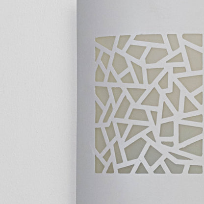 Closeup of decorative outdoor wall light panel featuring geometric cut pattern metal surface and modern architectural styling.