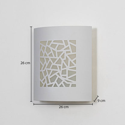 Modern outdoor wall light in white metal with geometric cut design mounted on wall showing 26 cm height 26 cm width and 9 cm depth.
