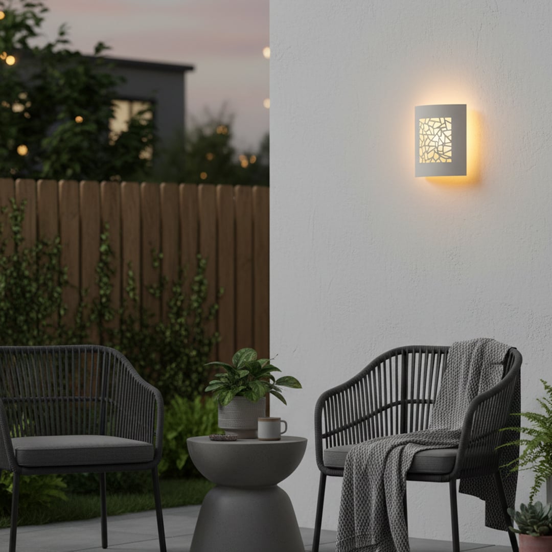 Elegant white ceramic wall light with geometric cutout design casting soft light patterns for stylish wall decor.