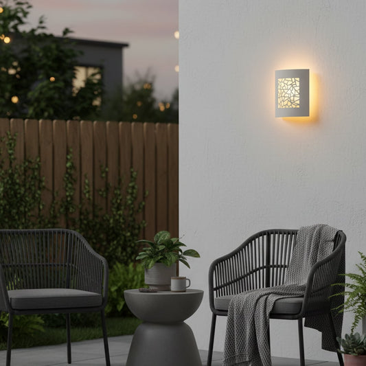 Elegant white ceramic wall light with geometric cutout design casting soft light patterns for stylish wall decor.