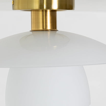 Closeup of gold metal ceiling light highlighting the smooth white glass shade and polished gold mount designed for modern elegant home lighting.