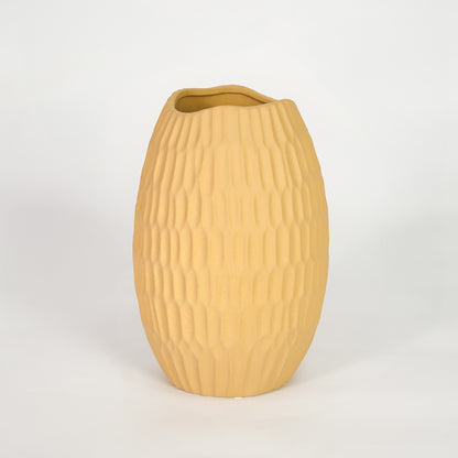 Yellow ribbed ceramic vase for modern shelf placement and elegant indoor home decor styling accent piece.