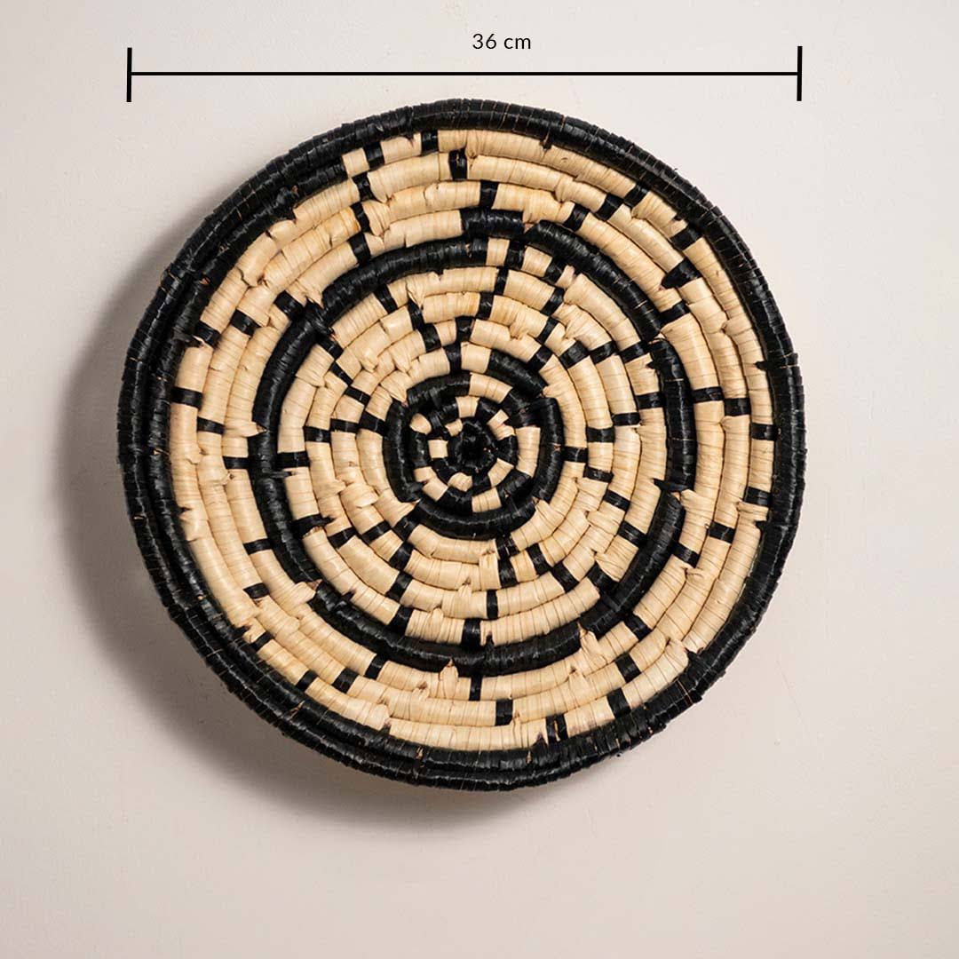 Dimension image of handcrafted black cream seagrass wall basket with concentric ring dash pattern for boho wall decor.