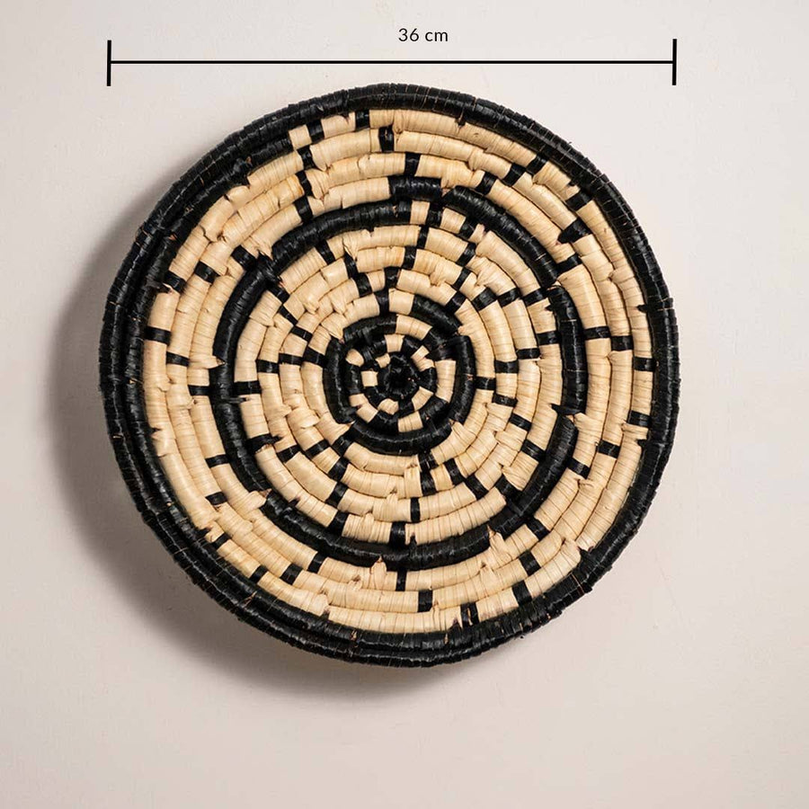 Dimension image of handcrafted black cream seagrass wall basket with concentric ring dash pattern for boho wall decor.