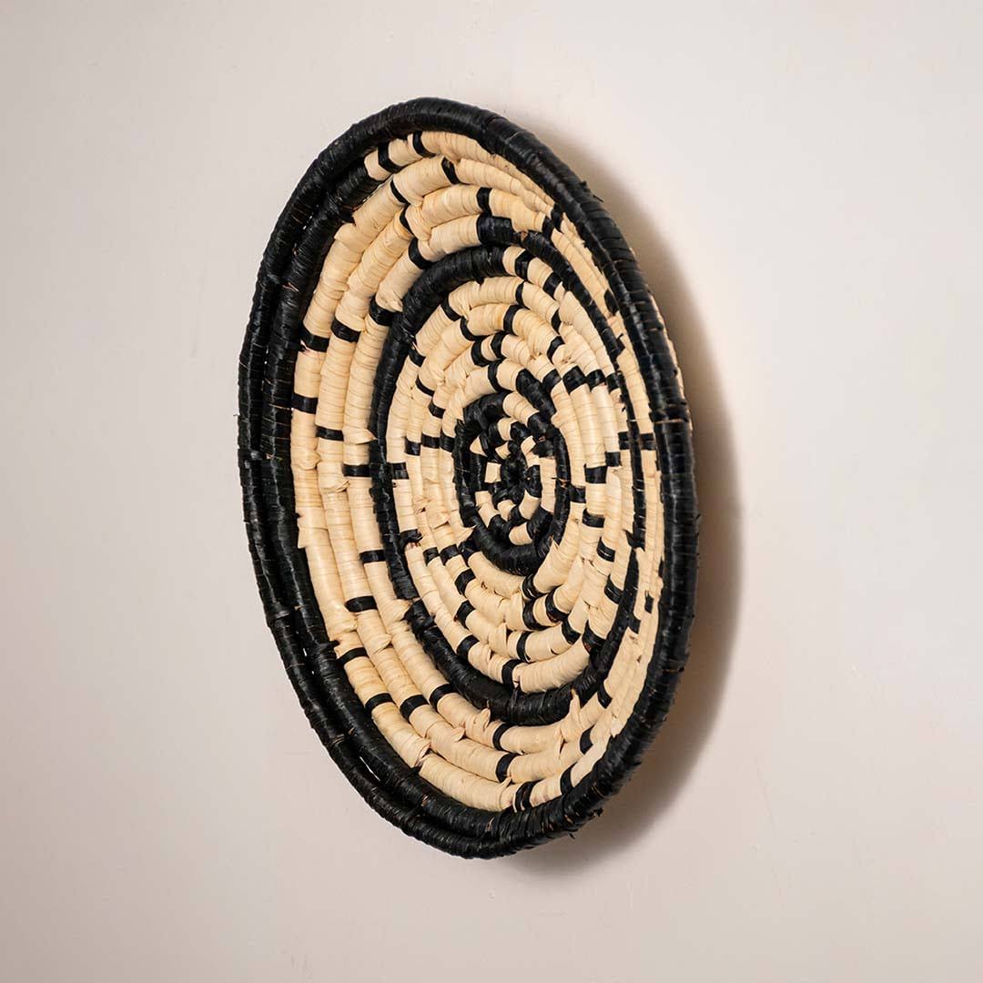 Side view of handcrafted black and cream woven seagrass wall basket with geometric dash pattern for boho wall decor styling.