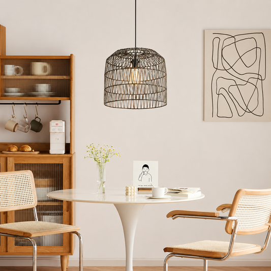 A black metal wire cage pendant light hangs over a white dining table in a modern, minimalist dining room with wooden chairs and a wooden shelving unit.