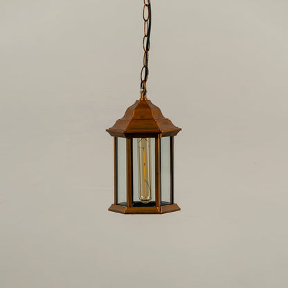 Copper metal hanging lantern on white background with light off showing clean hexagonal frame clear glass panels and traditional design suited for outdoor ceilings.