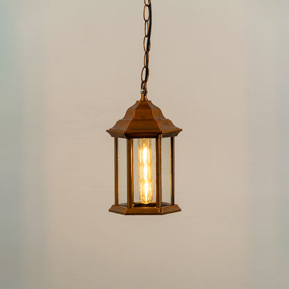 Copper metal hanging outdoor lantern with glass enclosure glowing on white background suitable for porch entrance and exterior decor lighting.