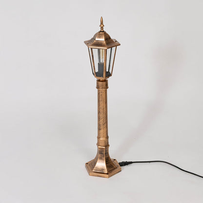Antique gold pillar lamp post with clear glass body displayed off on white background for outdoor decor.