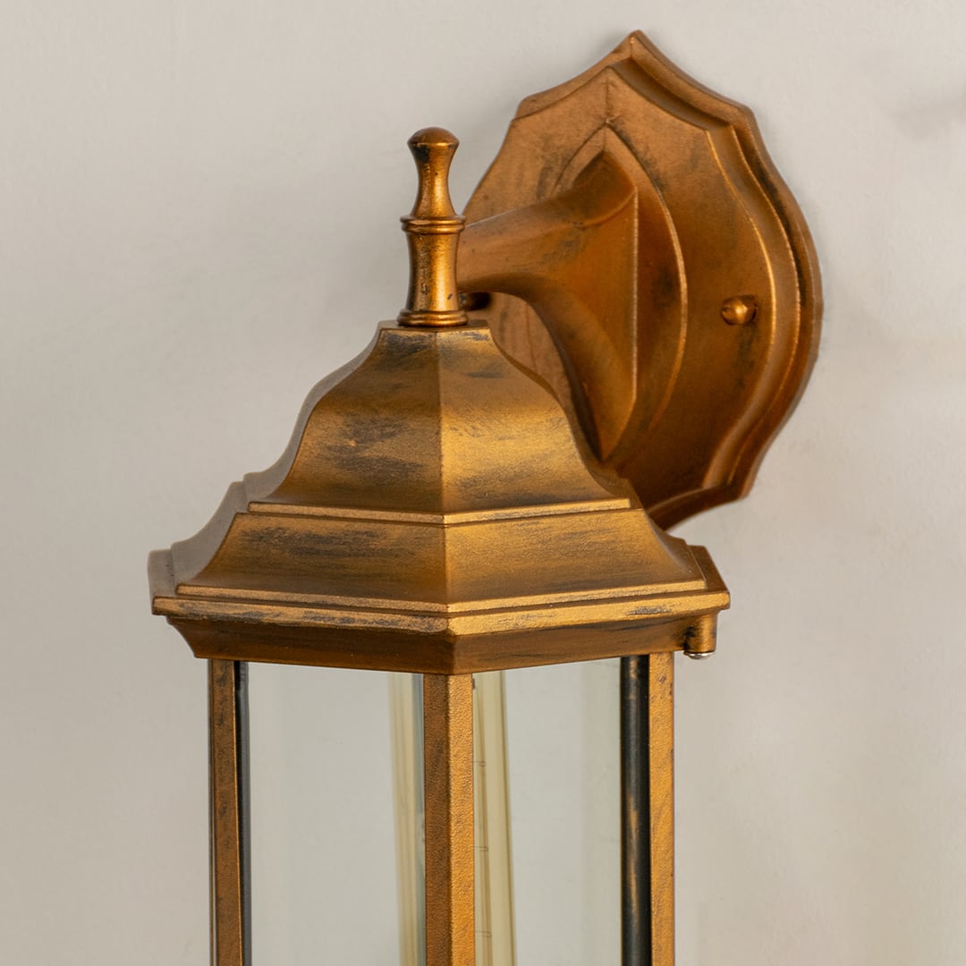 Antique brass outdoor wall lantern closeup image showing premium textured metallic finish and clear glass panels for decor.