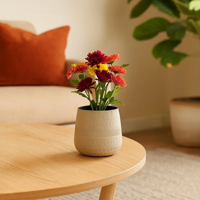 Cream textured decorative pot with black interior styled in a modern home setting adding soft minimal decor to shelves and tables.