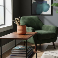 Textured terracotta vase with dried stems on wooden side table for cozy living room home decor and artistic accents.