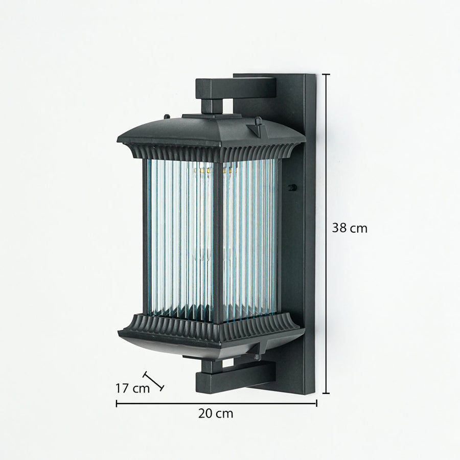 Outdoor wall light with black metal frame and ribbed glass enclosure mounted on wall 38 cm height 20 cm width 17 cm depth perfect for exterior lighting.