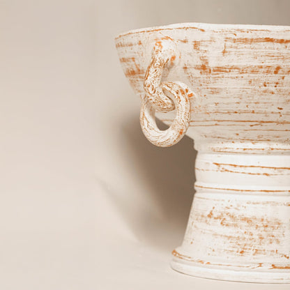 Closeup of white ceramic urn vase with distressed textured finish for elegant tabletop decor styling ideas.