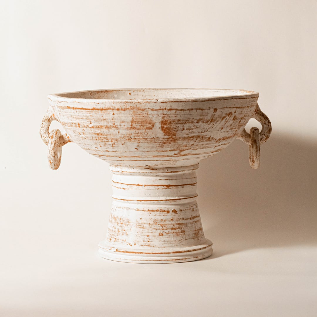 White ceramic decorative pedestal bowl with distressed finish for modern tabletop shelf and console decor placement.