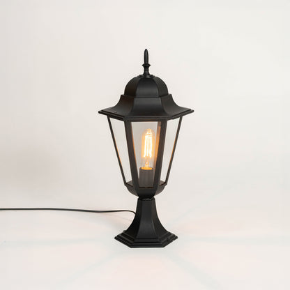 Modern black outdoor gate light with glowing bulb and glass shade for stylish exterior decor use.