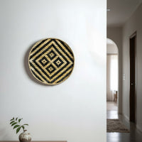 Geometric round wall decor in black and gold finish mounted on white wall enhancing modern hallway styling with bold visual appeal.