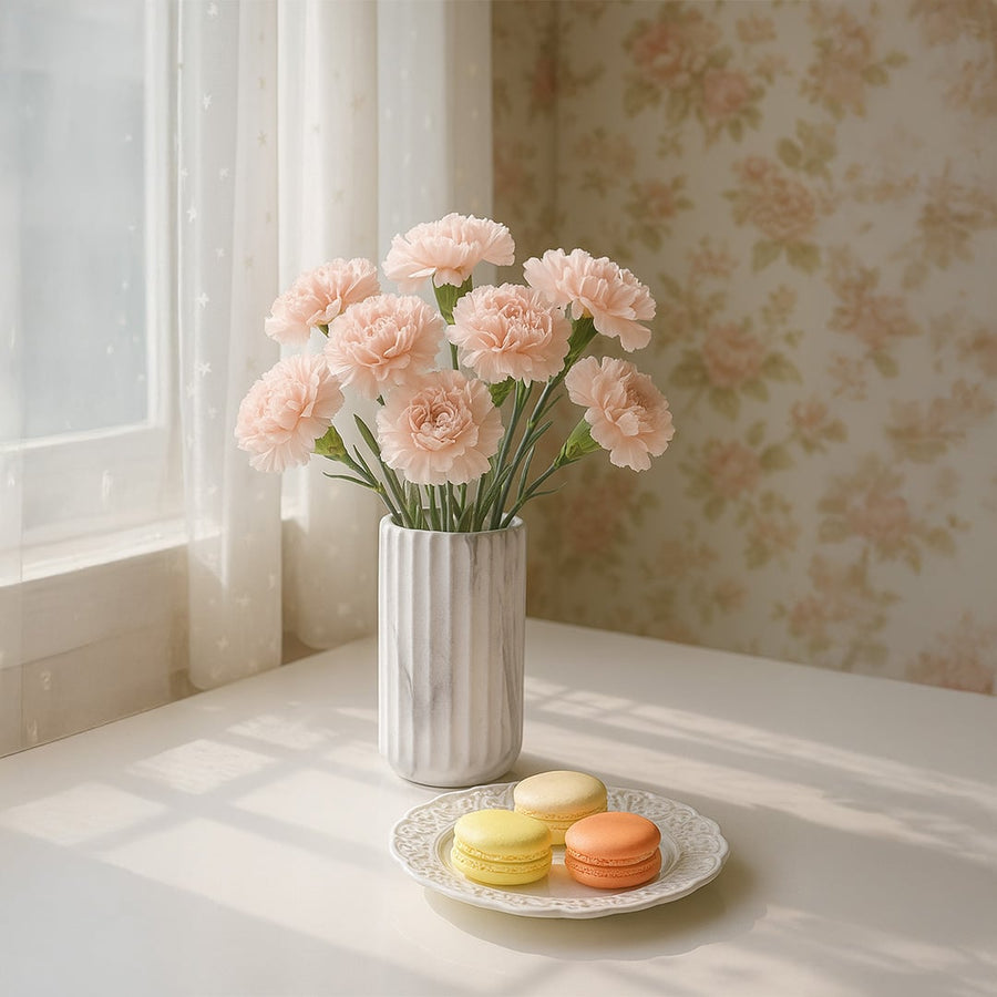 A marble textured cylindrical vase styled against a warm terracotta backdrop adding a refined modern accent to a minimal home setting.