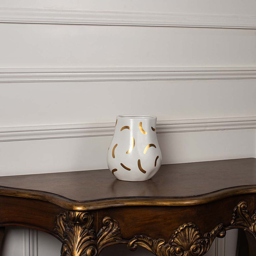 White ceramic decorative vase with gold abstract pattern styled on a vintage console table for elegant home decor.