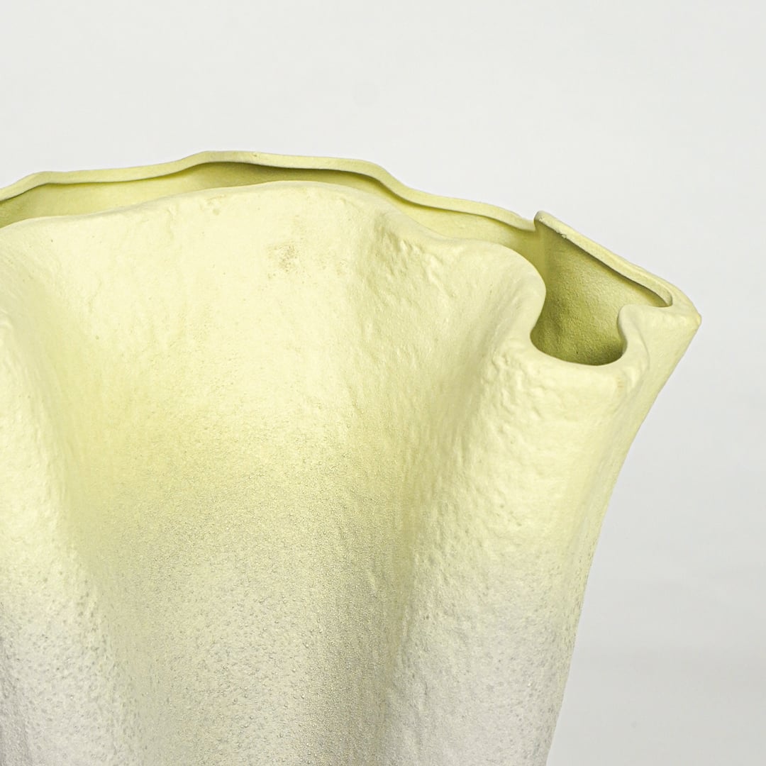 Close view of green gradient ceramic vase showing textured surface and sculpted rim detail for console or floor placement.