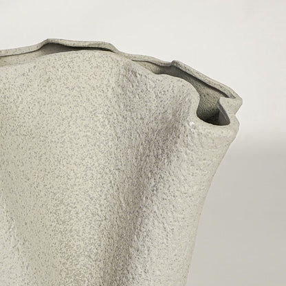 Close view of light beige ceramic vase highlighting textured matte surface and sculpted rim detail for modern decor styling.