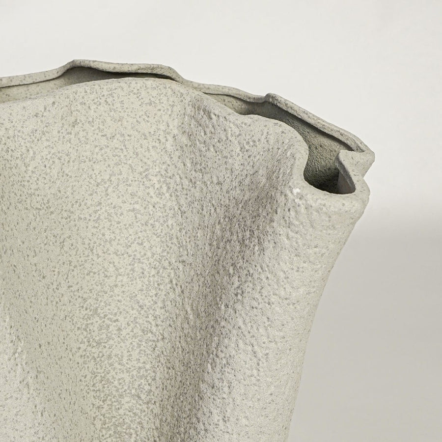 Close view of light beige ceramic vase highlighting textured matte surface and sculpted rim detail for modern decor styling.