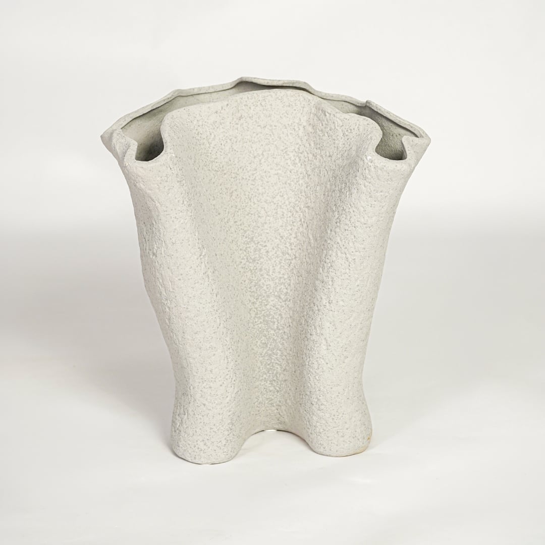 Modern light beige ceramic statement vase with flowing sculptural silhouette for living room console or shelf display.