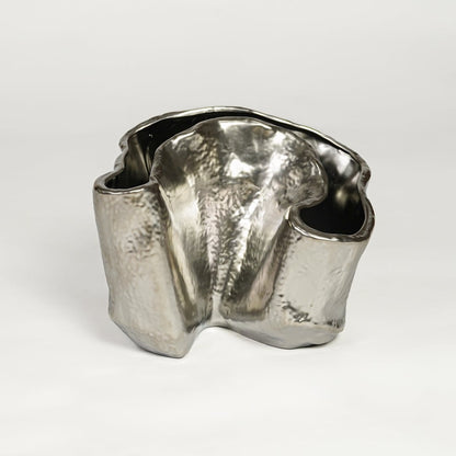 Silver metal decorative vase with sculpted organic design isolated on clean white background for luxury interior decor accent.
