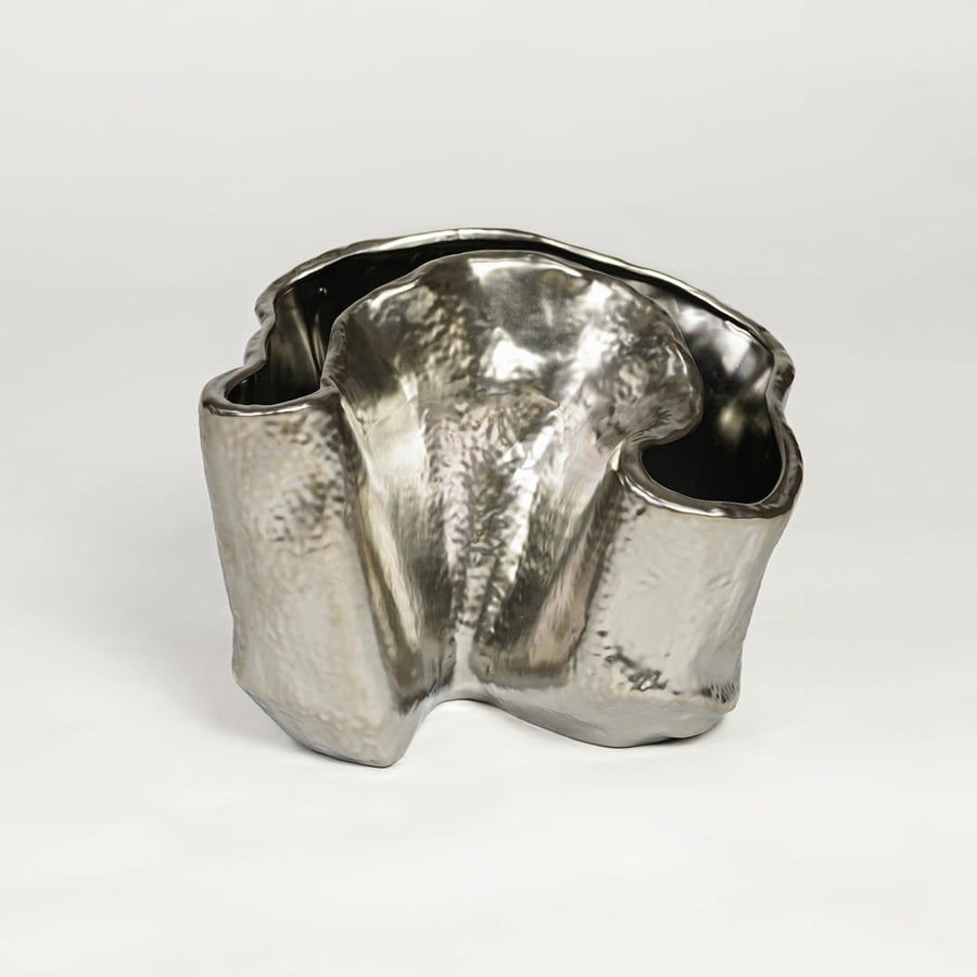 Silver metal decorative vase with sculpted organic design isolated on clean white background for luxury interior decor accent.