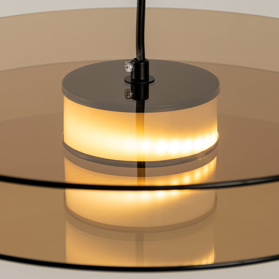 Closeup of brown wood and brass metal pendant light highlighting premium texture and craftsmanship.