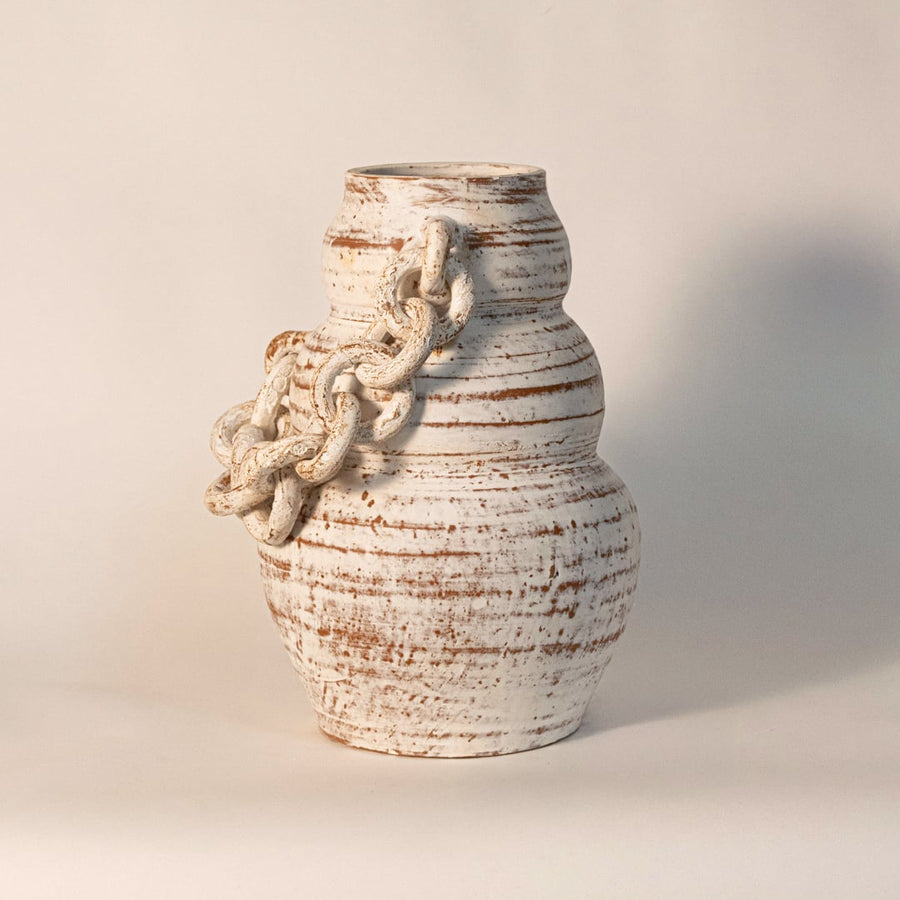 Large white chain vase placed on white background showcasing handcrafted ceramic texture and sculptural chain detail.