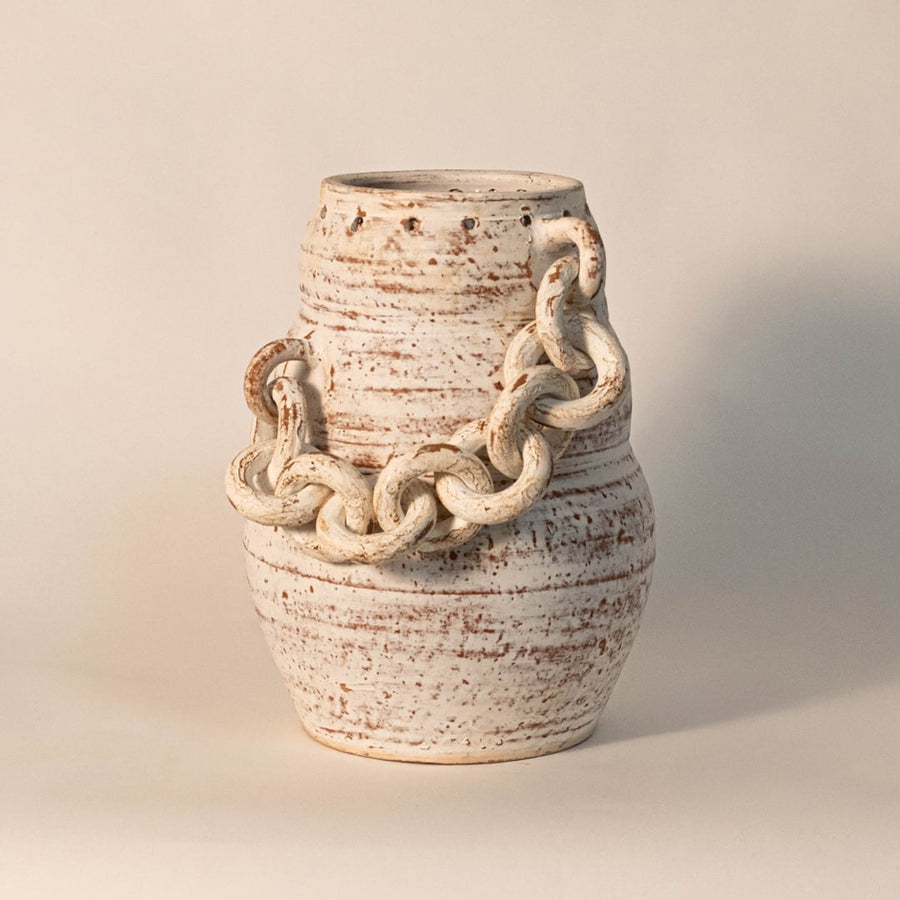 Chain vase displayed on off-white background surface under soft lighting emphasizing its rustic finish and handcrafted details.