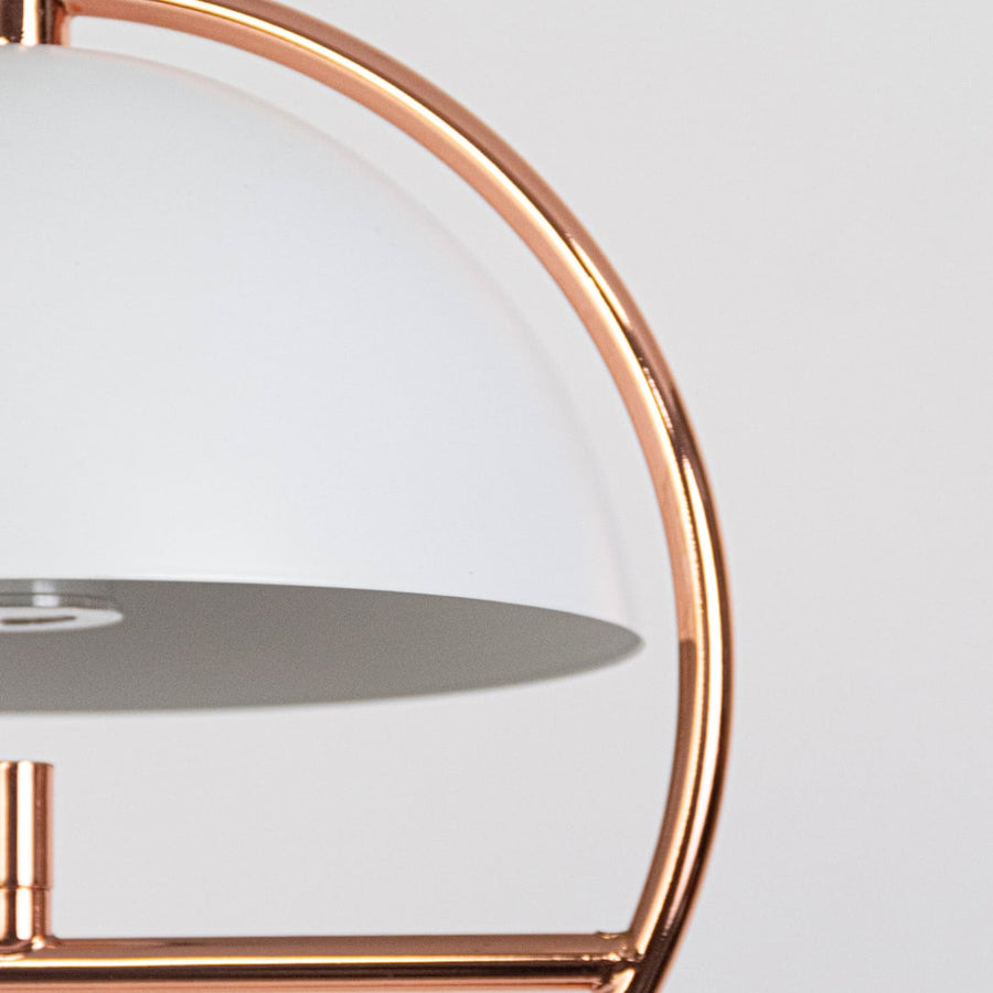 Closeup of rose gold pendant light featuring semi dome shade and circular metal frame with premium finish.