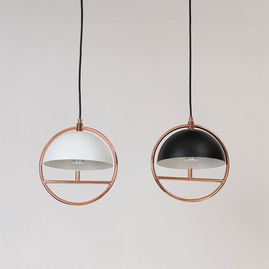 Pair of rose gold pendant ceiling lights with black and white dome shades displayed switched off.