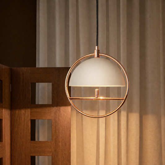 A modern pendant light with a frosted white dome shade and a copper-toned circular metal frame, hanging in front of beige curtains and a wooden screen.