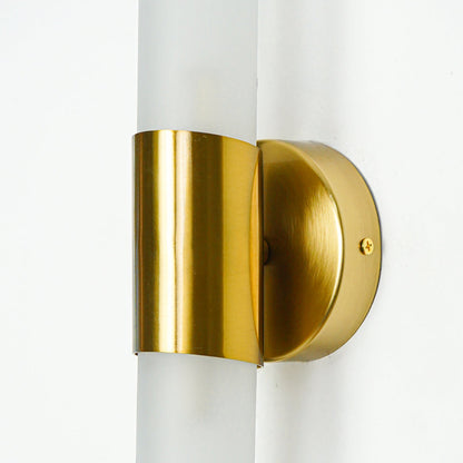 Close view of gold metal wall light with frosted glass tube highlighting premium modern lighting design on neutral background.
