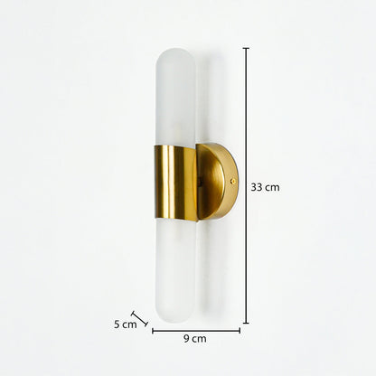 Modern wall light with frosted cylindrical glass and gold metal base mounted on neutral wall background 33 cm height 9 cm width 5 cm depth ideal for contemporary interior lighting.