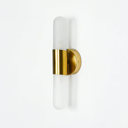 Minimal gold wall sconce with cylindrical frosted glass shade on clean white wall background perfect for contemporary interior decor lighting.