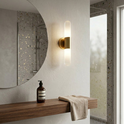 Stylish wall sconce with black glass shade and gold arm installed beside mirror in modern bathroom setting ideal for ambient lighting.

