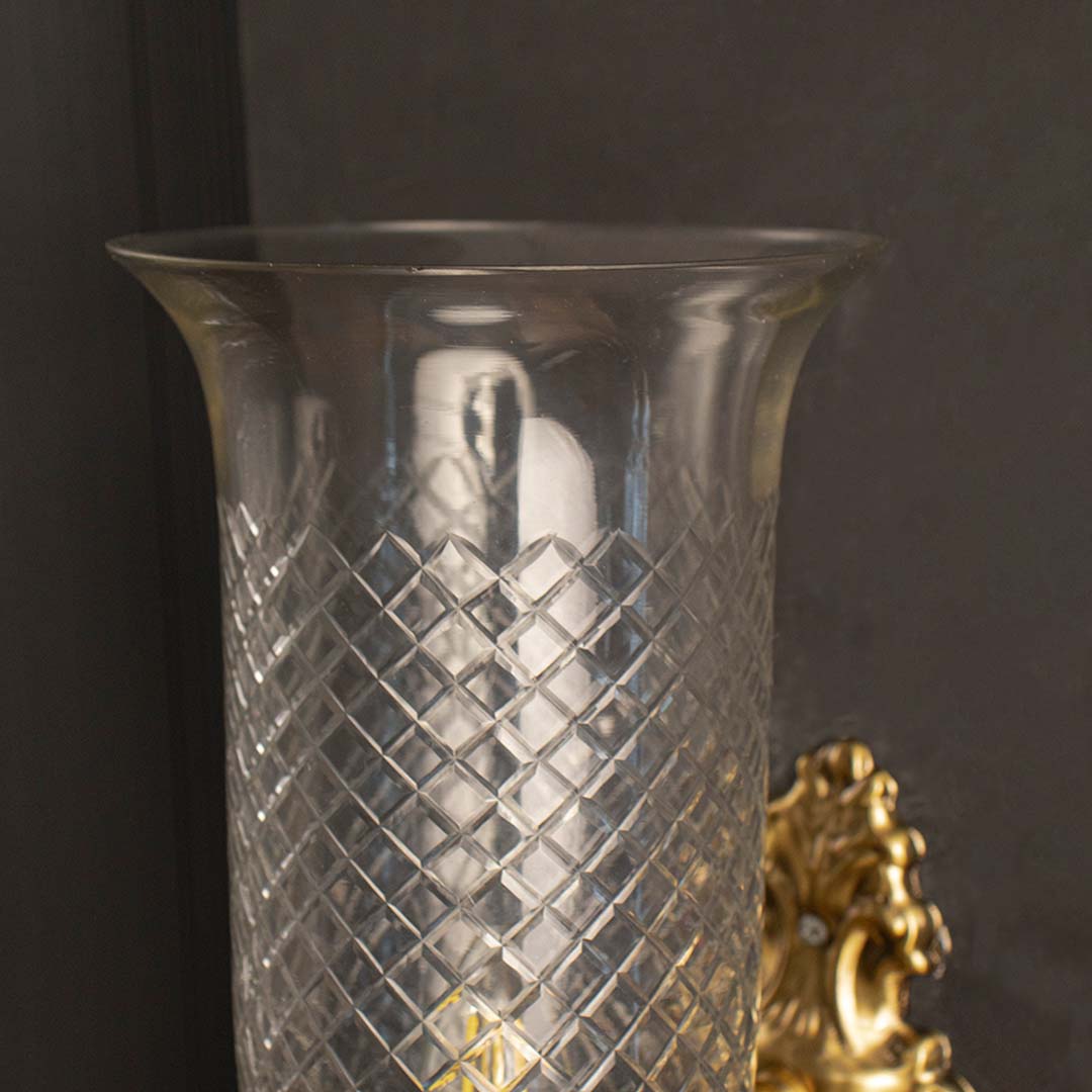 Detailed closeup view of the ornate scroll design on the brass backplate and diamond etching on the glass shade.