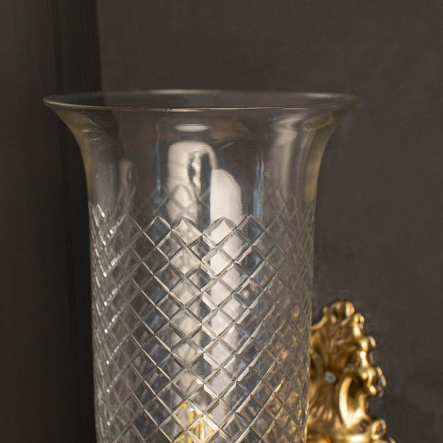 Detailed closeup view of the ornate scroll design on the brass backplate and diamond etching on the glass shade.