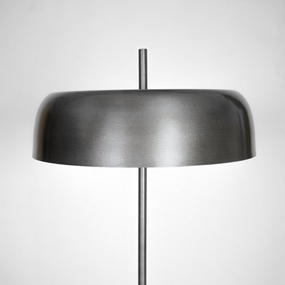 Closeup of black metal table lamp with wide dome shade for bedside table and modern home decor lighting display.