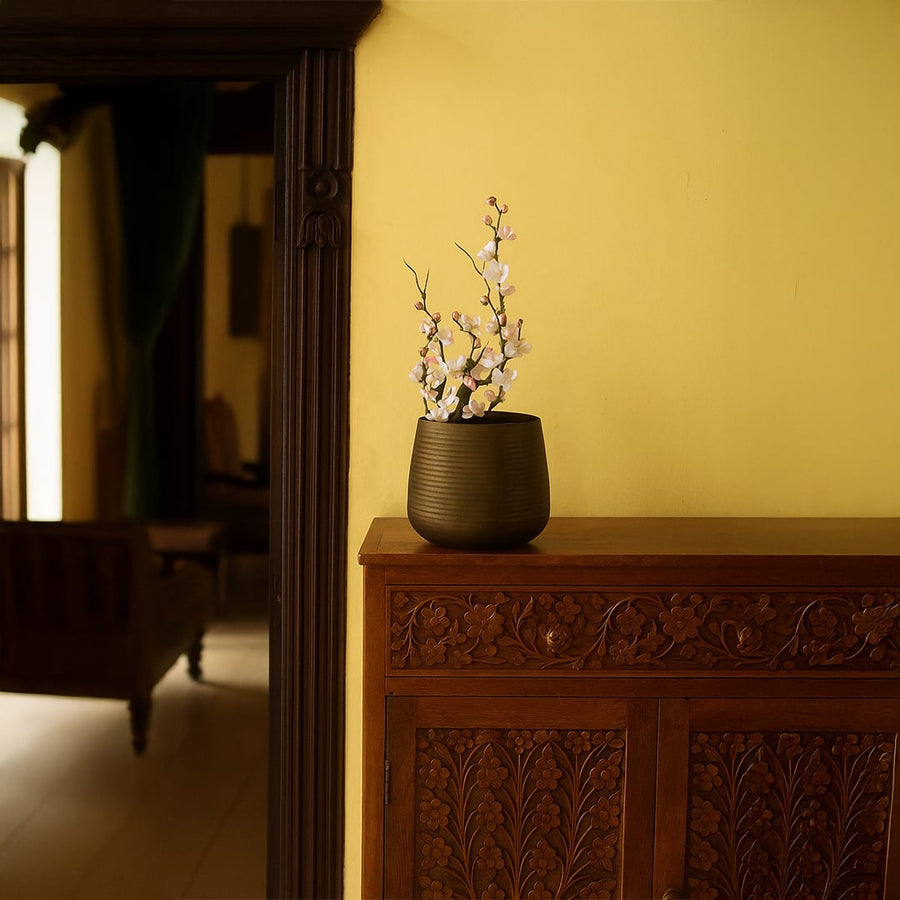 Brown metal planter decor styled in a cozy contemporary interior bringing warm earthy charm to living room consoles.