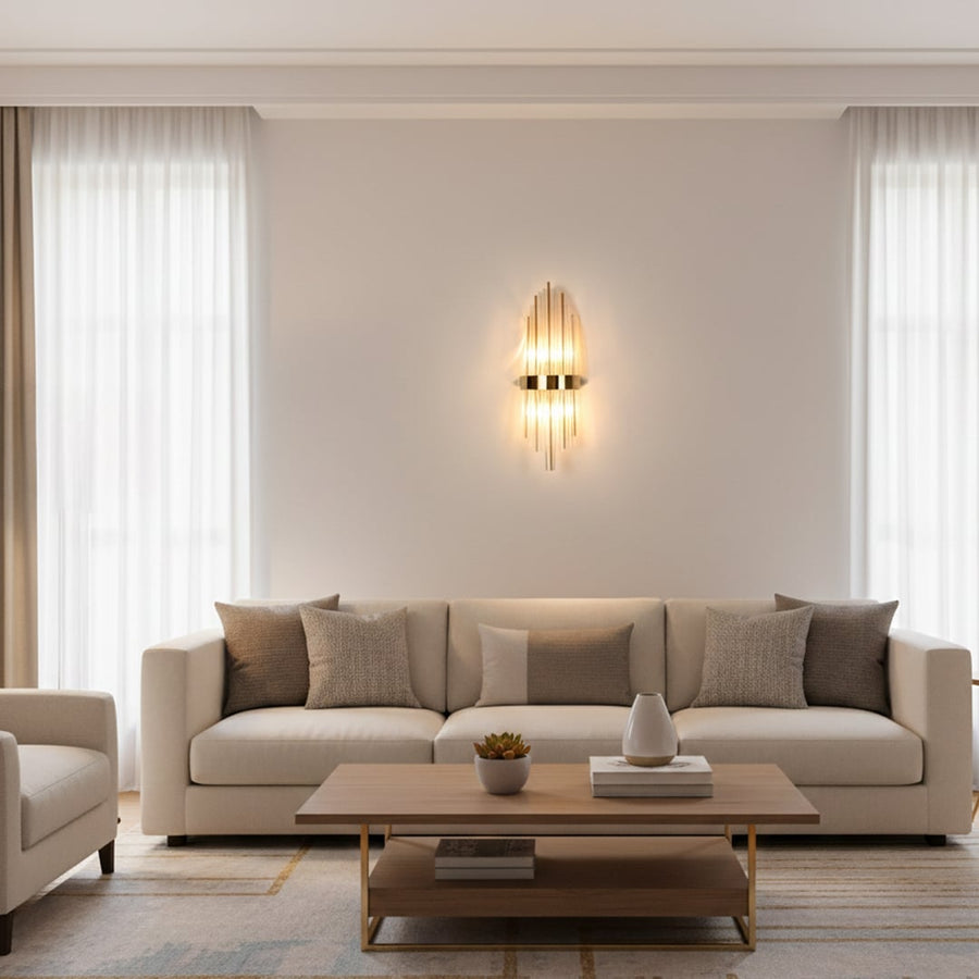 Gold metal and clear crystal wall light styled on luxury interior wall creating dramatic vertical lighting for modern elegant homes.