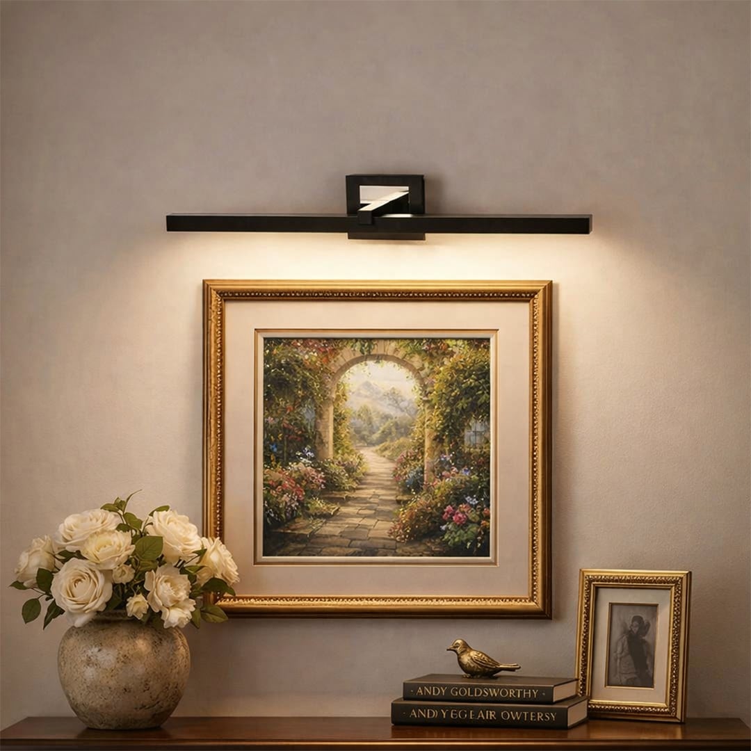 Black and gold metal picture light illuminating framed artwork with warm focused lighting for elegant gallery style decor.