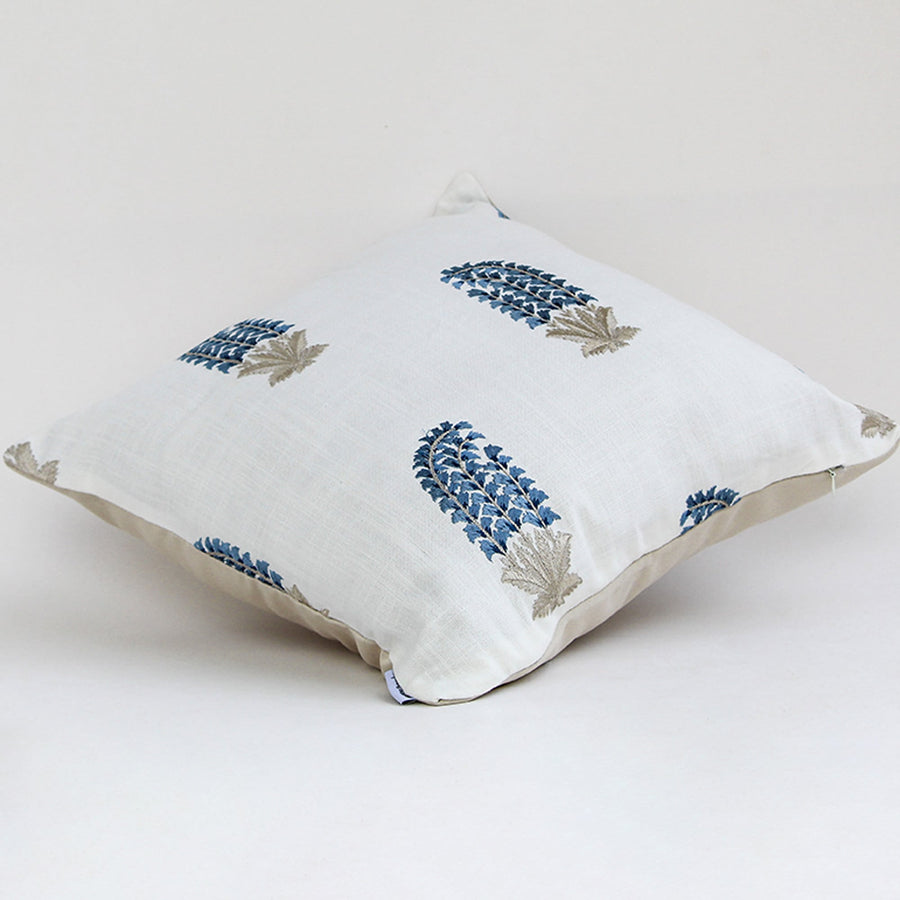 White cushion cover featuring repeating blue floral motifs smooth fabric finish and modern decorative cushion design on white background.
