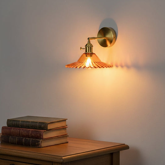 Vintage style amber glass wall light mounted on warm toned wall creating cozy ambient glow above wooden console with classic decor for elegant living spaces.