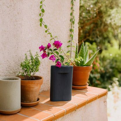 Black rectangular ceramic vase with vertical ribbed texture displayed on white background for modern home decoration.